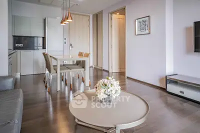Modern open-plan living room with sleek kitchen and stylish dining area, featuring elegant decor and natural light.