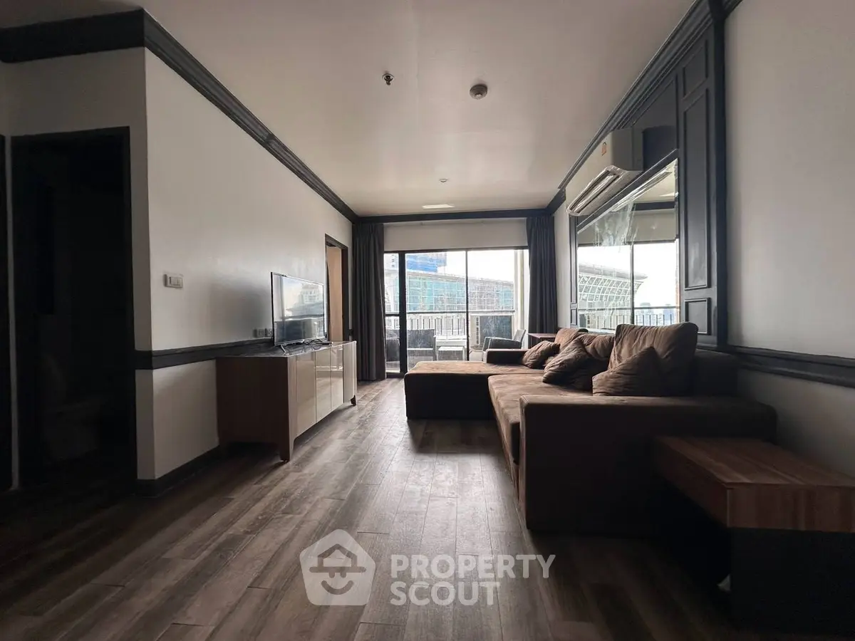 Spacious living room with modern decor and large windows offering city views