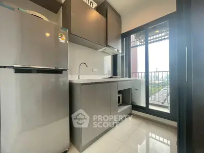 Modern kitchen with sleek cabinets and balcony view, perfect for urban living.