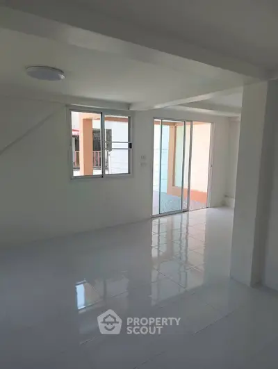 Spacious unfurnished room with large windows and sliding glass doors, perfect for customization.