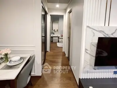 Modern apartment hallway with elegant dining setup and TV area