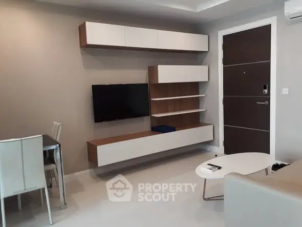 Modern living room with sleek furniture and wall-mounted TV in a stylish apartment.