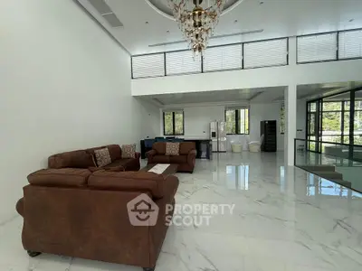 Luxurious open-plan living room with elegant marble flooring and plush brown sofas, perfect for modern living.