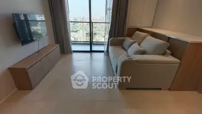 Modern living room with city view, featuring sleek furniture and large windows for natural light.