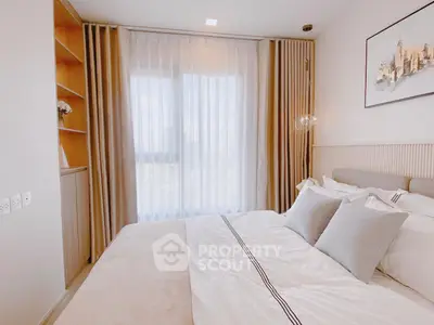 Luxurious bedroom with elegant decor and large window offering natural light
