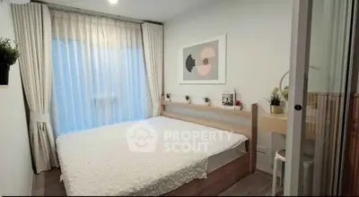 Cozy bedroom with modern decor and large window, perfect for relaxation and comfort.