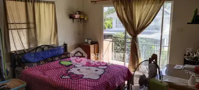 Cozy bedroom with large window and charming decor, offering a bright and inviting atmosphere.