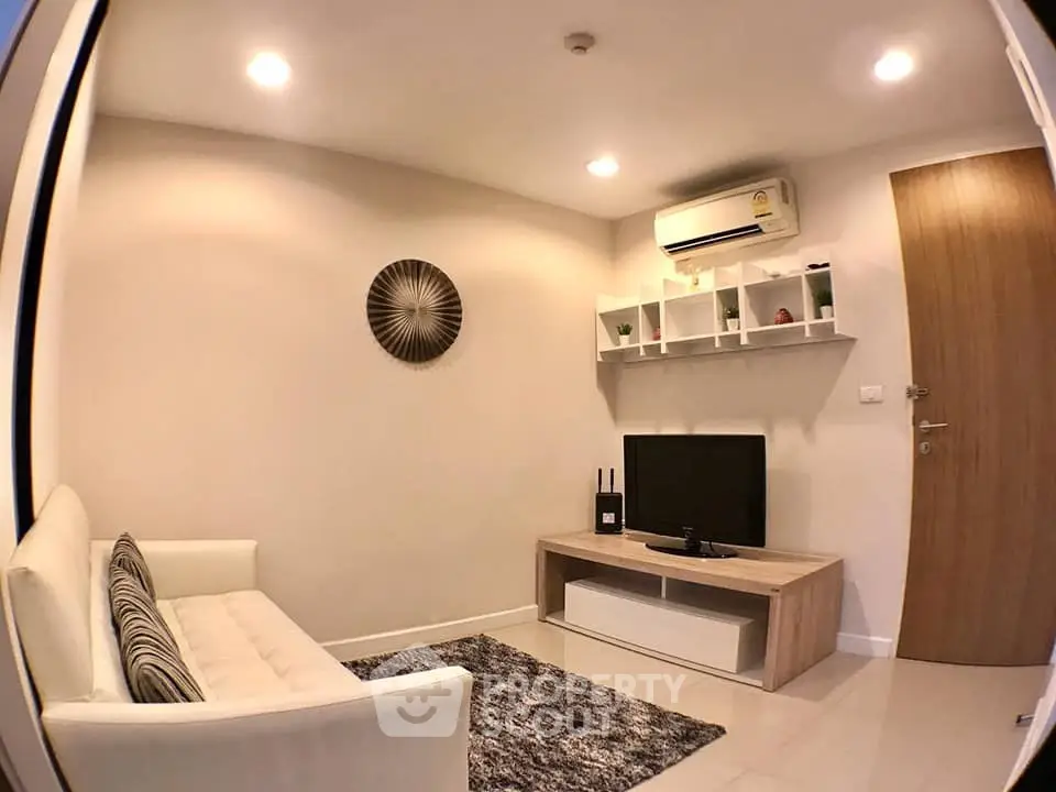 Cozy living room with modern decor, featuring a comfortable sofa, wall-mounted TV, and stylish shelving.