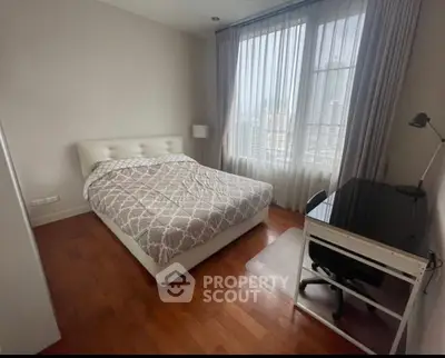 Spacious bedroom with city view, featuring a cozy bed and modern desk setup.
