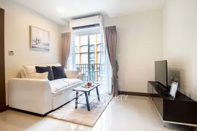 Modern living room with cozy sofa, sleek TV stand, and balcony view in a stylish apartment.