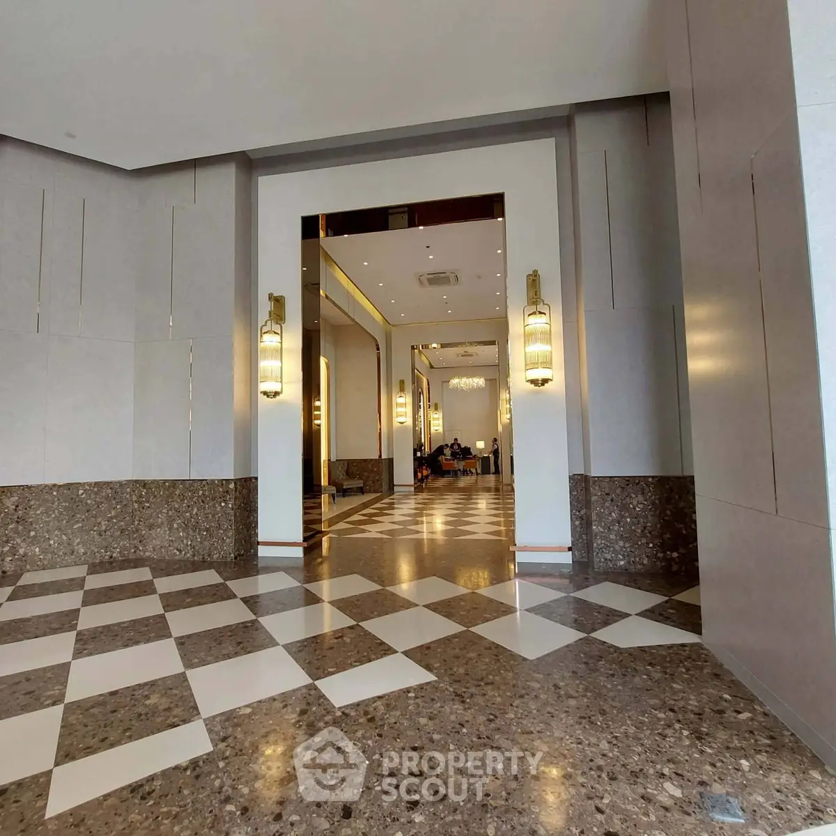 Elegant building entrance with luxurious marble flooring and stylish lighting fixtures.