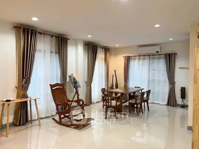Spacious living room with elegant wooden furniture and large windows for natural light.