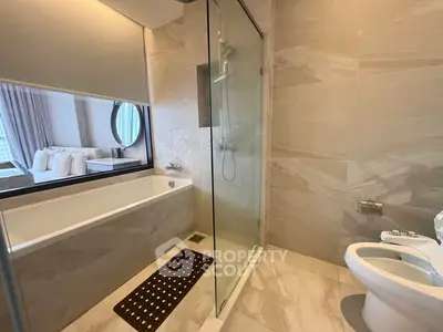 Luxurious bathroom with modern shower and bathtub in elegant apartment.