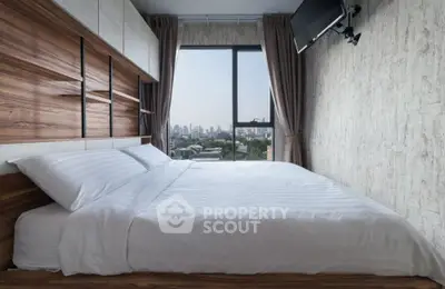 Modern bedroom with city view, featuring stylish decor and large window for natural light.