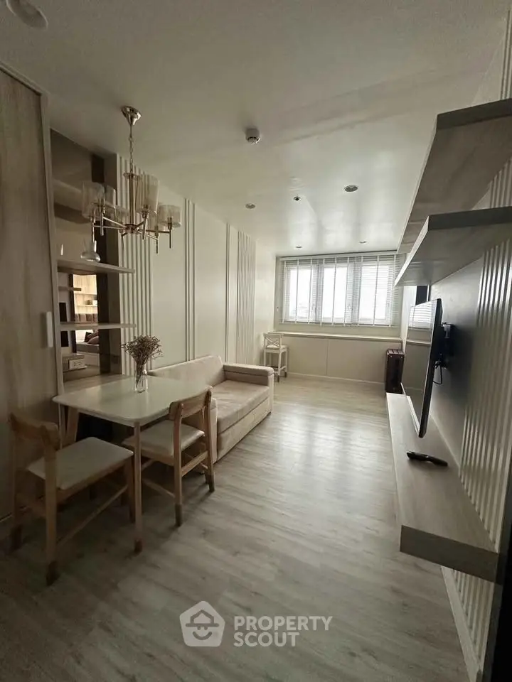 Modern living room with sleek design, featuring a cozy sofa, dining table, and wall-mounted TV.