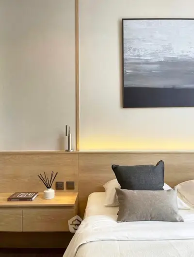 Modern bedroom with stylish decor and cozy ambiance, featuring elegant artwork and soft lighting.