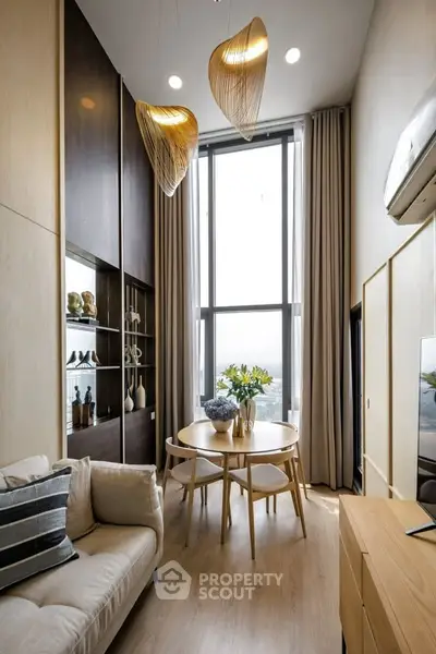 Modern living room with high ceiling, elegant lighting, and stylish decor.