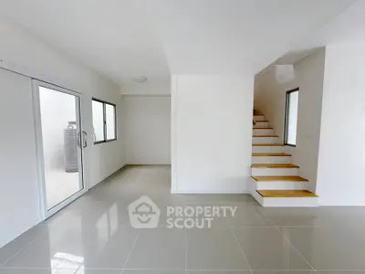 Modern minimalist interior with sleek staircase and large windows