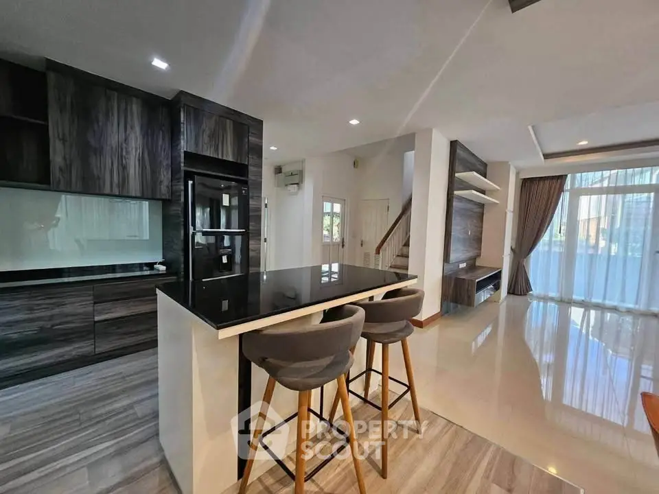Modern open-plan kitchen and living area with sleek design and natural light.