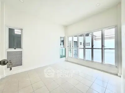Bright and spacious empty room with large windows and tiled floor, perfect for customization.