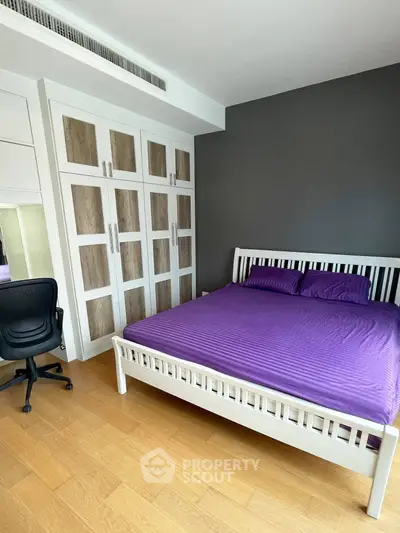 Spacious bedroom with modern design, featuring a comfortable bed and ample closet space.