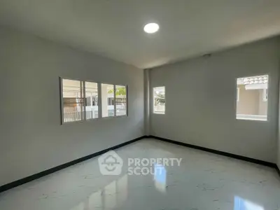 Spacious empty room with large windows and glossy tiled floor, perfect for customization.