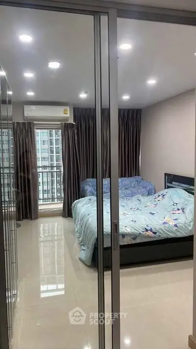 Spacious bedroom with large windows and modern decor in high-rise apartment.