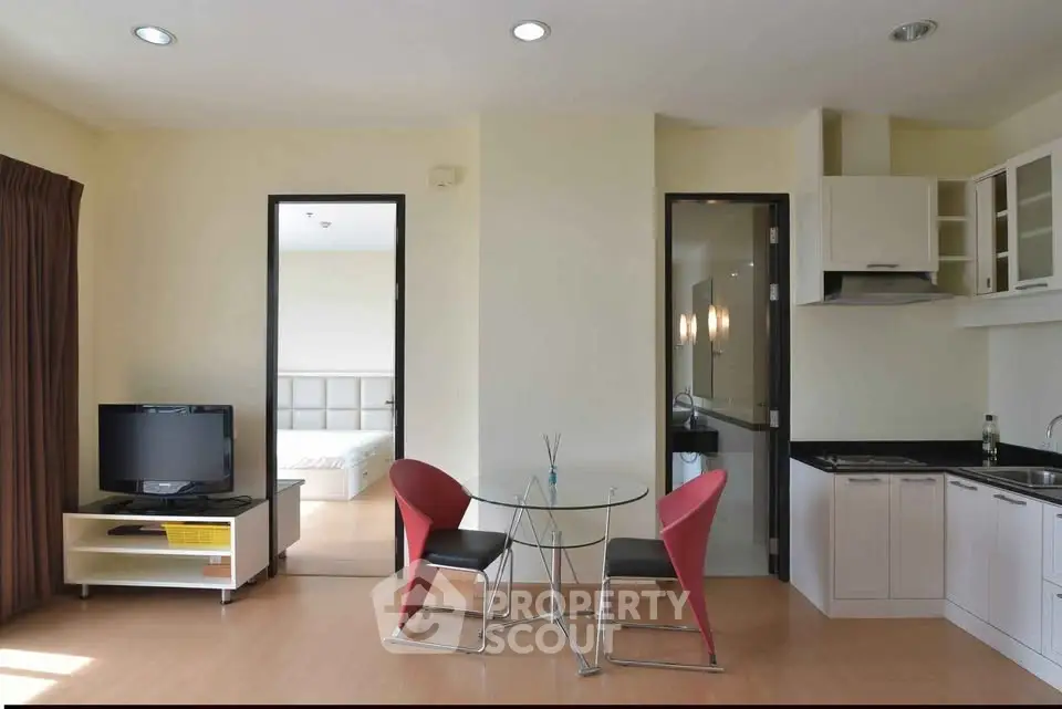 Modern open-plan living room with kitchen and dining area in a stylish apartment.