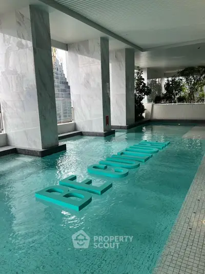 Luxurious indoor pool with modern design and city view, perfect for relaxation and leisure.
