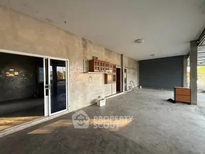 Spacious industrial-style garage with concrete floors and ample storage space.