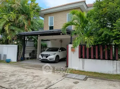 Charming suburban home with lush greenery and covered parking in a peaceful neighborhood.
