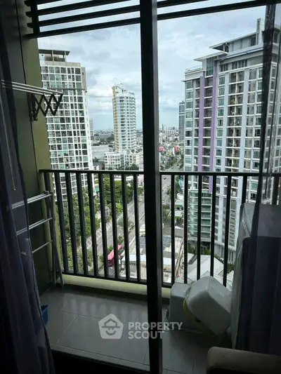 High-rise city view from a modern apartment balcony with sleek railing.