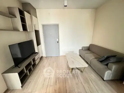 Modern living room with sleek furniture and flat-screen TV, perfect for relaxation.