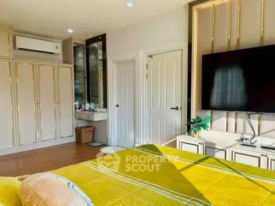 Luxurious bedroom with modern decor, large TV, and ample storage space.