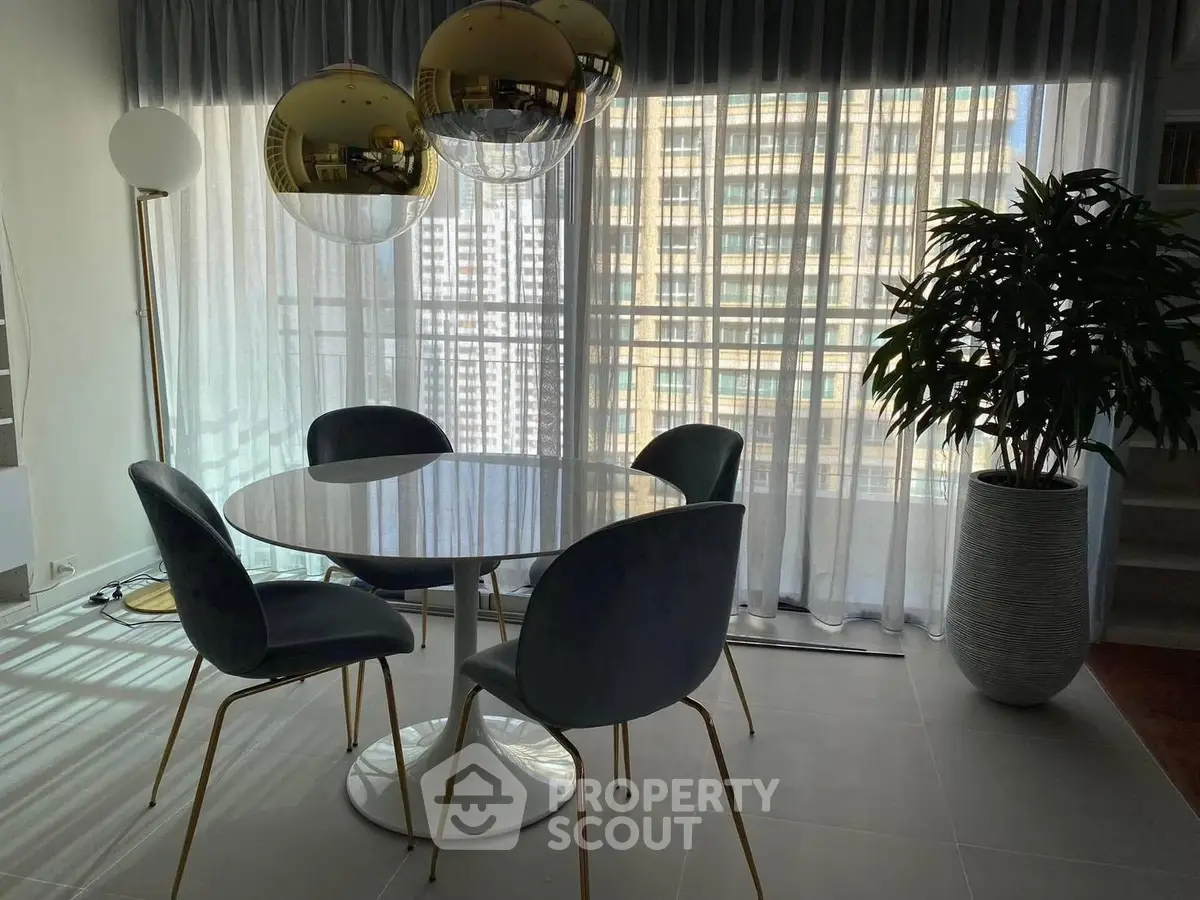 Modern dining area with round table and stylish chairs in high-rise apartment