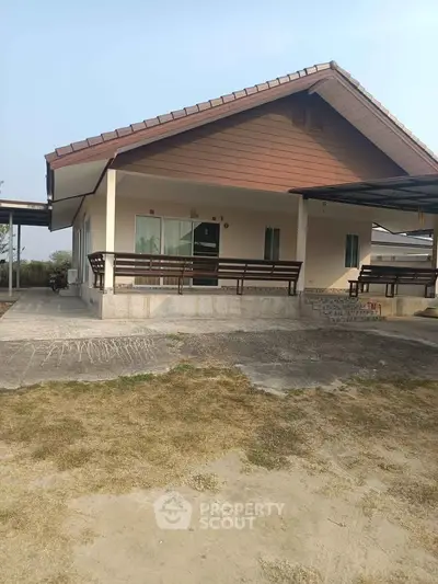 Charming single-story house with spacious front yard and covered porch.