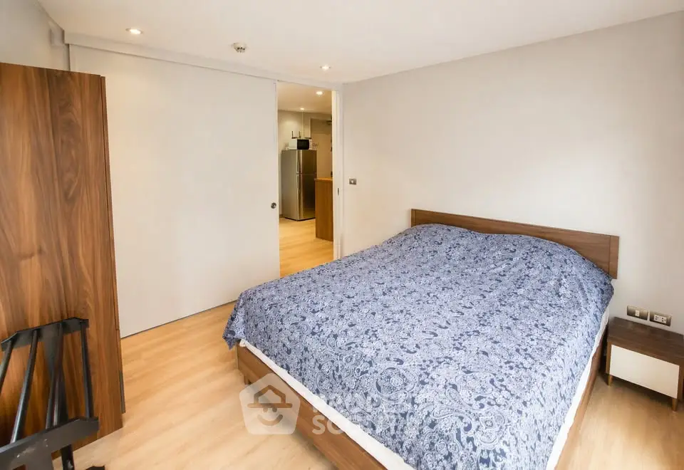 Spacious bedroom with wooden furniture and modern decor in a stylish apartment.