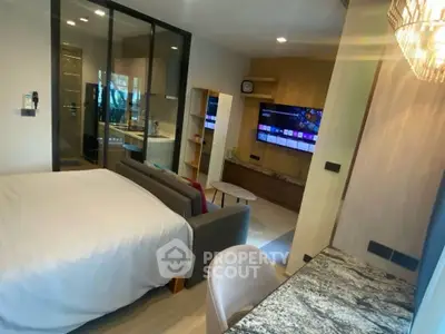 Modern studio apartment with stylish decor and open layout, featuring a cozy bed and sleek entertainment area.