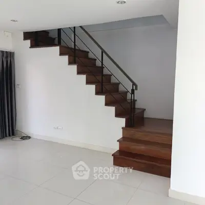 Modern interior with sleek staircase and polished floors in a spacious living area.