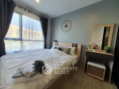 Modern bedroom with large window and stylish decor in a contemporary apartment.