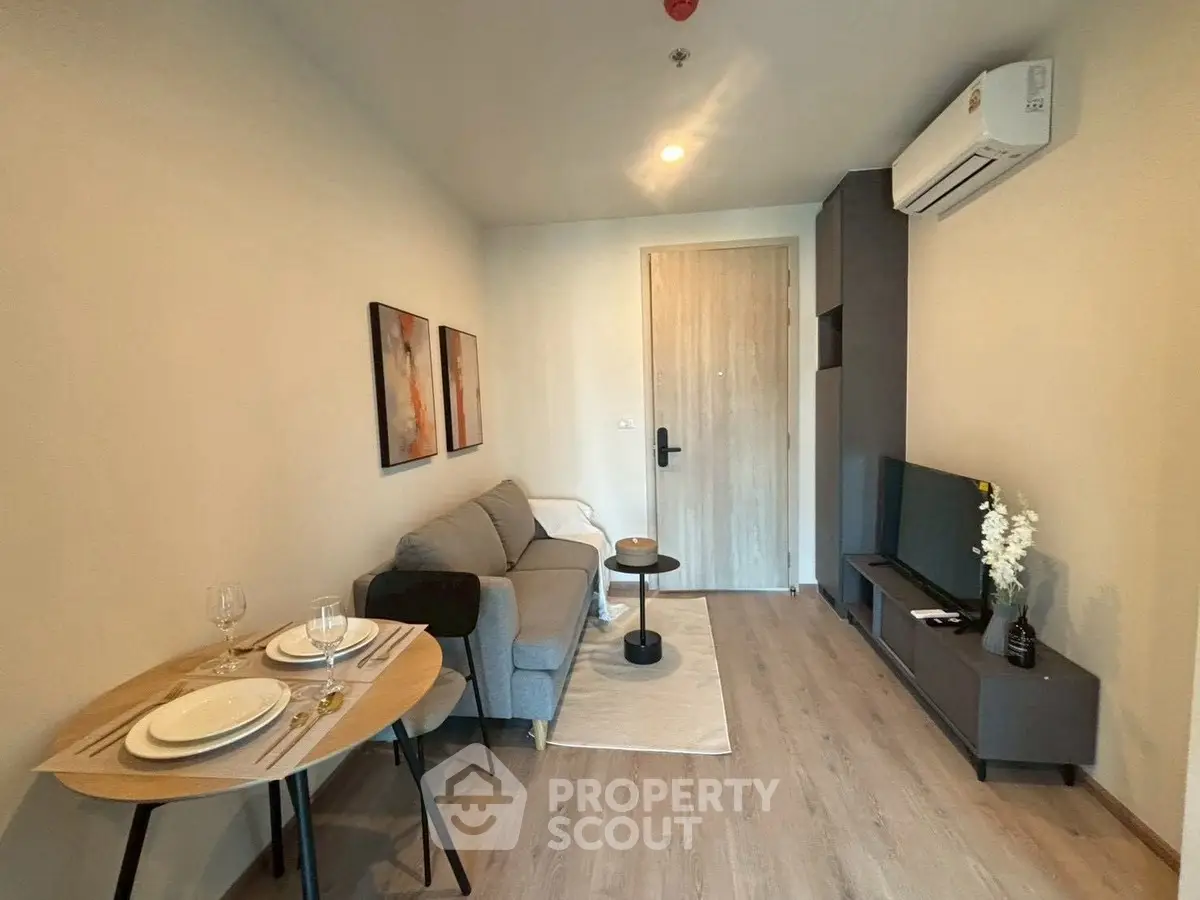 Cozy modern living room with sofa, TV, and dining area in stylish apartment.