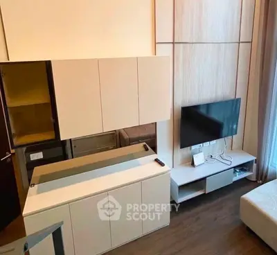 Modern living room with sleek cabinetry and wall-mounted TV, featuring stylish wood flooring and contemporary design.