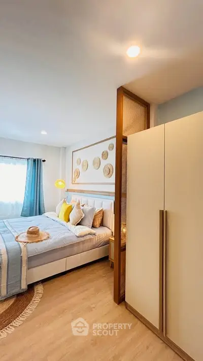 Cozy bedroom with stylish decor and natural light, featuring a comfortable bed and modern wardrobe.