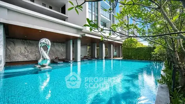 Luxurious residential pool with modern sculpture and lush greenery