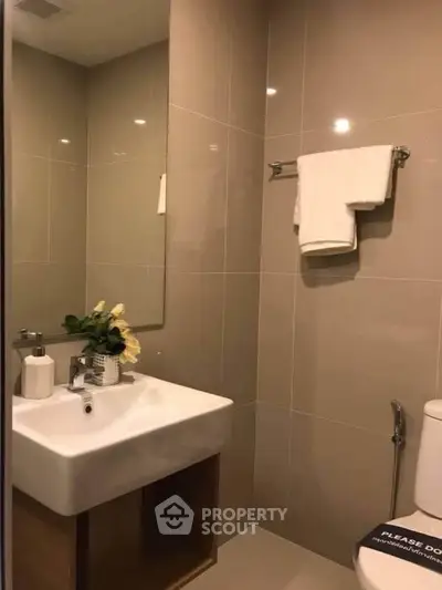 Modern bathroom with sleek sink and elegant tiles, perfect for a contemporary home.