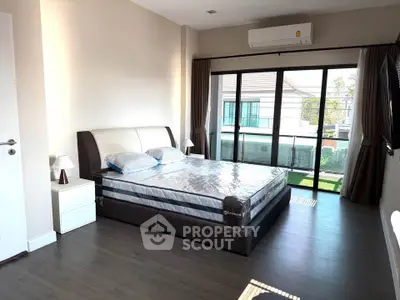 Spacious bedroom with large window and modern furnishings in a bright home