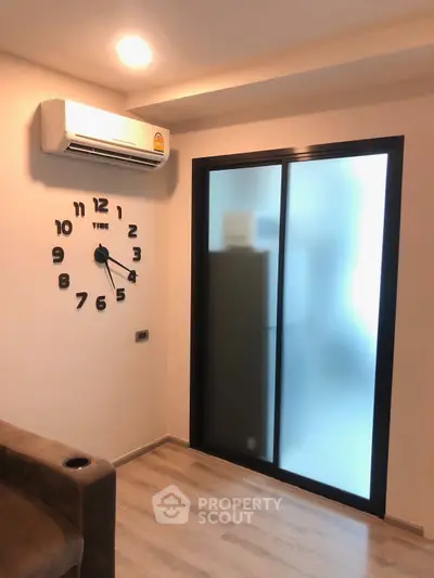 Modern living room with unique wall clock and frosted glass sliding door