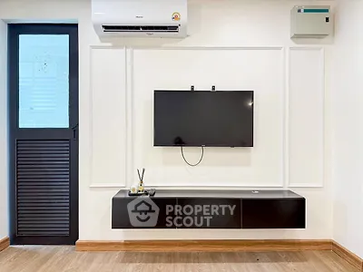 Modern living room with wall-mounted TV and sleek black console