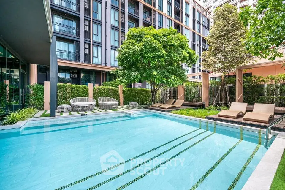 Luxurious apartment complex with modern pool and lush greenery, perfect for relaxation and leisure.