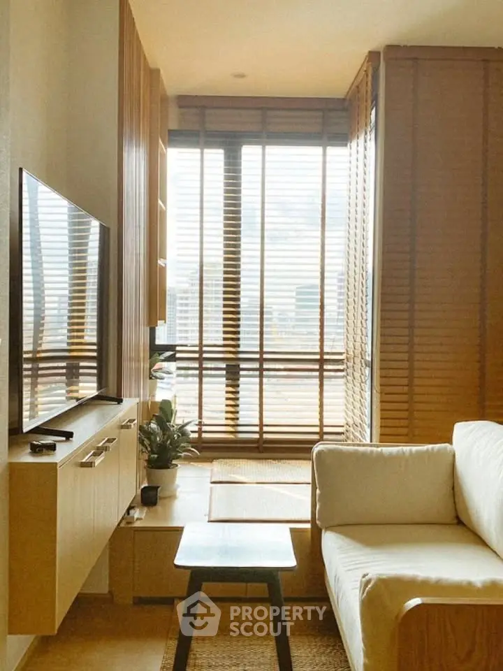 Cozy living room with modern decor and large window offering city views.
